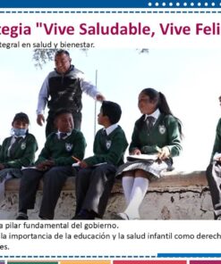 Una maestra interactúa con un grupo de escolares uniformados, sentados en un muro bajo en el exterior. En la pancarta se puede leer 