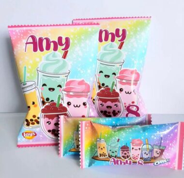 Paquetes coloridos con adorables bebidas de dibujos animados, como batidos y té de burbujas con caritas felices. El fondo es un degradado pastel con destellos. El texto dice "Amy & Oreo" y "Lay's".