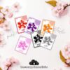 Seis coloridas tarjetas con pulpos de dibujos animados en rojo, morado, naranja, rosa, negro y gris, cada uno etiquetado con un nombre de color en español, sobre un fondo claro con flores rosas.