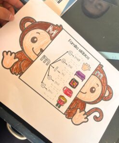 Una mano sostiene una hoja de ejercicios con un mono de dibujos animados y un cuadro titulado 