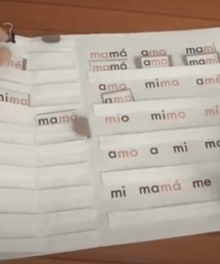 Una persona interactuando con 22 Cuadernos Dinámicos de Lectura Globalizada hechos en casa que presentan paneles doblados entrelazados etiquetados con palabras en español relacionadas con 