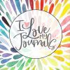 La imagen es un patrón vibrante y multicolor de formas de lágrimas alargadas que irradian hacia afuera. En el centro, un área circular contiene el texto "Amo mis diarios" con un pequeño símbolo de corazón sobre la 'I', combinándose perfectamente con el diseño del Diario/Cuaderno de Notas Arte Abstracto.