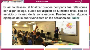 Una maestra de pie frente a una clase explica información proyectada en una pantalla. Varios estudiantes en sus asientos levantan la mano mientras ven al frente. El aula tiene decoraciones y materiales didácticos.