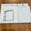 Una hoja de trabajo titulada "Interactivo para reporte de libro" se muestra sobre una superficie de madera. Este reporte de libro interactivo presenta secciones para "Personajes principales", "Eventos más importantes", "El ambiente" y "Mi opinión". Incluye una ilustración del libro vacía, espacios para el título del libro, el autor y un breve resumen.