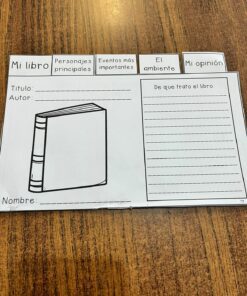 Una hoja de trabajo titulada "Interactivo para reporte de libro" se muestra sobre una superficie de madera. Este reporte de libro interactivo presenta secciones para "Personajes principales", "Eventos más importantes", "El ambiente" y "Mi opinión". Incluye una ilustración del libro vacía, espacios para el título del libro, el autor y un breve resumen.