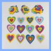 Doce corazones de papel de colores, superpuestos, dispuestos debajo de tres pequeñas pilas de recortes con forma de corazón.