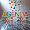 Sobre una superficie de mármol aparecen letras de colores que rezan "AGENDA 2025-2026", hechas con terrones de azúcar, y desde arriba caen caramelos de distintas formas (corazones, estrellas, mariposas). Una luz brillante brilla desde la izquierda.
