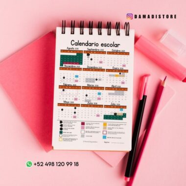Un calendario escolar encuadernado en espiral en español sobre fondo rosa con artículos de papelería, como bolígrafos y cuadernos. El calendario muestra los meses de agosto de 2023 a julio de 2024 y destaca los días festivos y las fechas importantes.