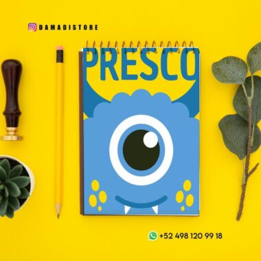 Un cuaderno de colores con un simpático monstruo azul de dibujos animados en la portada titulado "PRESCO" está colocado sobre una superficie amarilla junto a un lápiz, una planta verde, un sello y hojas de eucalipto. Se ven los datos de contacto y las direcciones de las redes sociales.