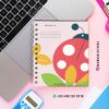 Agenda docente preescolar ciclo 2025-2026 catarina 19 Un colorido cuaderno de espiral con un diseño de mariquita está colocado sobre un escritorio junto a un ordenador portátil, una calculadora y un rotulador fluorescente rosa. La cubierta del cuaderno tiene hojas y colores llamativos. Los datos de contacto y las cuentas de redes sociales están visibles.
