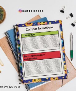 Un cuaderno de espiral con la cubierta decorada con emojis de colores descansa sobre un escritorio con bolígrafos, clips y una planta. La página del cuaderno muestra texto en español en 