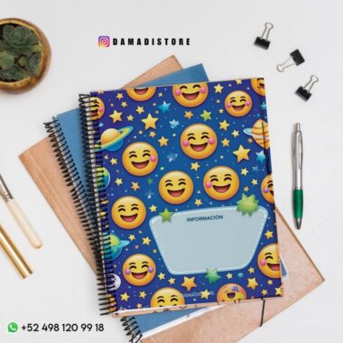 Encima de unas carpetas hay un cuaderno de espiral con un emoji de colores y un planeta en la portada que pone "INFORMACIÓN". Cerca hay una planta, bolígrafos, clips y un número de contacto de WhatsApp visible.