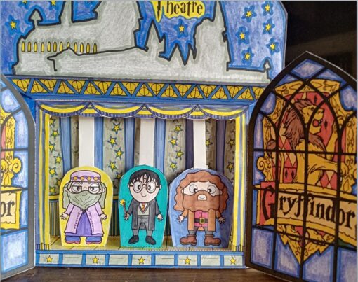Un colorido diorama de papel hecho a mano representa una escena de teatro con tres personajes inspirados en un tema de mago. El fondo muestra la silueta de Hogwarts contra un cielo nocturno estrellado, con "Teatro Guiñol Hogwarts" escrito en una pancarta. Los lados tienen intrincados diseños de vidrieras y "Gryffindor" escrito a la derecha.