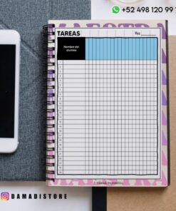 Cuaderno de espiral abierto a una tabla de tareas con nombres de alumnos y meses, colocado sobre un escritorio junto a un smartphone. El usuario de Instagram @damadistore y el número de WhatsApp son visibles.
