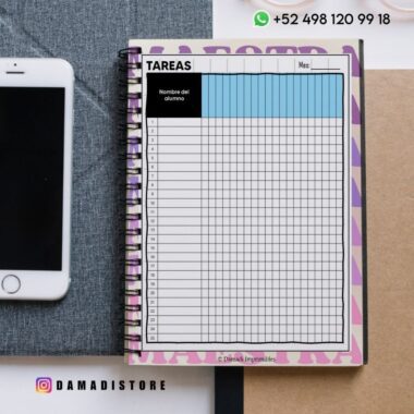 Cuaderno de espiral abierto a una tabla de tareas con nombres de alumnos y meses, colocado sobre un escritorio junto a un smartphone. El usuario de Instagram @damadistore y el número de WhatsApp son visibles.