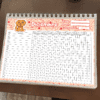 Un planificador de calendario escolar para diciembre en un cuaderno de espiral, con imágenes de dibujos animados de un perro y garabatos con temas escolares en la parte superior, con títulos en español como 