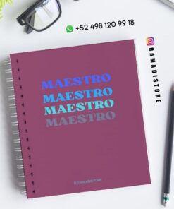 Un cuaderno de espiral con "MAESTRO" escrito cuatro veces en diferentes tonos de azul en la portada, colocado sobre un escritorio en el que se muestran gafas, un bolígrafo, una planta y la información de contacto de DAMADISTORE.