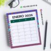 Agenda docente primaria 2025-2026 letras 11 Una agenda de enero de 2026 está sobre un escritorio con un lápiz, una planta y unas gafas cerca. En la imagen aparece un número de contacto de WhatsApp y la cuenta de Instagram @damadistore.