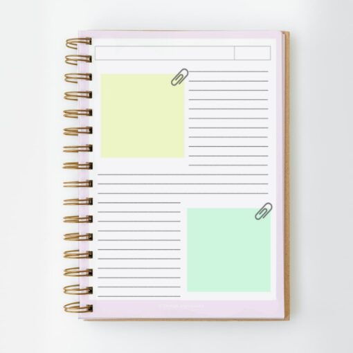 Un cuaderno de espiral, con la etiqueta "Cuaderno PDF Mang BT21 BTS 135 hojas", está abierto y muestra una página dividida en secciones. El lado izquierdo tiene dos notas adhesivas de color pastel, una amarilla y otra verde claro, cada una asegurada con un clip. El lado derecho presenta secciones rayadas para escribir. La portada del portátil es visible y está adornada con caracteres BT21.