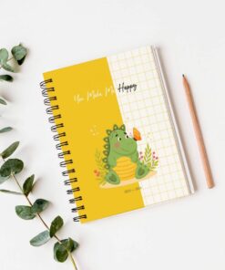 Un Cuaderno de estudio - Dinosaurio (100 hojas) encuadernado en espiral y con tapa amarilla que presenta una caricatura de un dinosaurio verde sentado entre plantas, sosteniendo una mariposa. El texto 