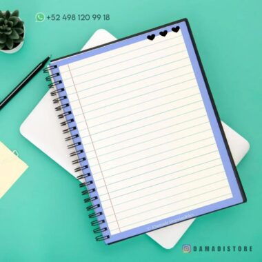 Sobre una mesa blanca hay un cuaderno de espiral con tapa azul abierto. El Cuaderno de raya con diseño de rana tiene páginas rayadas con tres corazones negros en la esquina superior derecha. Se ven un bolígrafo negro, una pequeña planta suculenta, una nota adhesiva amarilla y la información de contacto "+52 498 120 99 18". Una marca de agua dice "@DAMADISTORE".