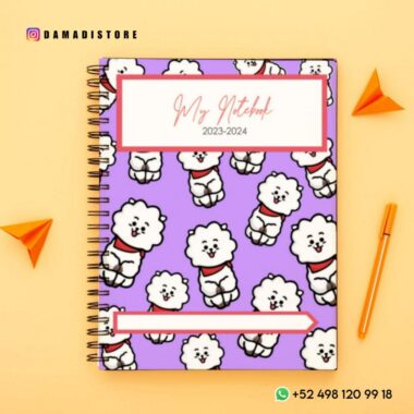 Un cuaderno encuadernado en espiral con una cubierta morada que presenta un patrón repetido de perros de dibujos animados con collares rojos. En la portada se muestra el título "Mi cuaderno 2023-2024". El fondo incluye aviones de papel naranja e información de contacto de Damadistore. Parte de la colección PDF Paquete de cuadernos BT21.