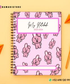 Un cuaderno de espiral rosa con un divertido estampado de conejitos y el texto 