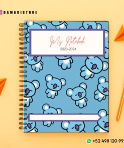 Un cuaderno encuadernado en espiral con cubierta azul que presenta un patrón repetido de lindas ilustraciones de koalas. El PDF del Paquete de cuadernos BT21 se titula 