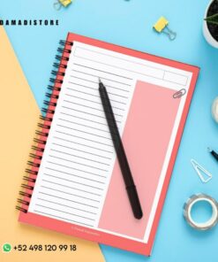 Un Cuaderno BT21 VAN, encuadernado en espiral, de color rojo, abierto por una página rayada con una columna en blanco y un bolígrafo negro colocado en diagonal. Suministros de oficina como una planta, clips para carpetas, rollos de cinta adhesiva y clips rodean el cuaderno. Los datos de contacto y un identificador de redes sociales son visibles en las esquinas, lo que da a entender el encanto de BT21.