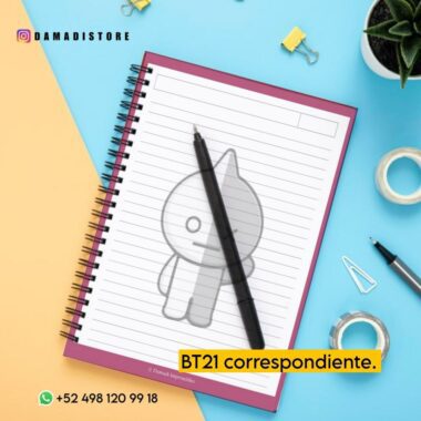 Vista superior de un escritorio con varios elementos, como un Cuaderno BT21 VAN con un personaje de dibujos animados, un bolígrafo negro, clips, una chincheta y una pequeña planta. El texto "BT21 correspondiente." aparece en un cuadro amarillo y la información de contacto aparece en la parte inferior.