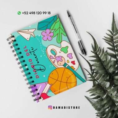 Un cuaderno encuadernado en espiral con una cubierta colorida con divertidas ilustraciones, que incluyen una pelota de baloncesto, una paleta de pintura, un avión de papel y flores. En la portada aparece el título "Diario del Sueño". Cerca se colocan un bolígrafo negro y una planta de helecho. La información de contacto y el logotipo se encuentran en la parte superior e inferior.