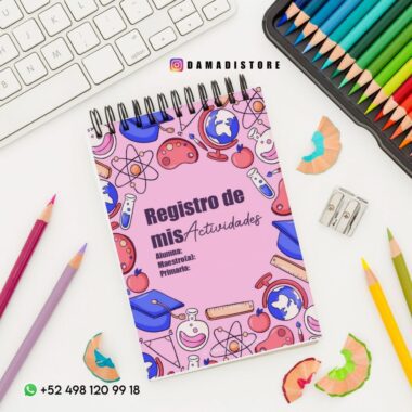 Un cuaderno titulado "Registro de mis Actividades" con coloridas ilustraciones escolares en la portada. Está colocado sobre un escritorio con lápices de colores, un sacapuntas, virutas y parte de un teclado visible. Se muestran el número de contacto y la cuenta de Instagram.