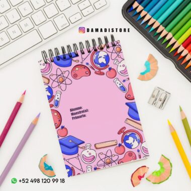 Un espacio de trabajo colorido incluye un cuaderno con ilustraciones escolares, como globos terráqueos y átomos, sobre una cubierta rosa, rodeado de lápices de colores, un sacapuntas, virutas de lápiz y un teclado. La información de contacto se muestra en la parte inferior.