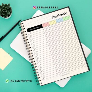 Una hoja de asistencia encuadernada en espiral sobre una superficie verde azulado, con columnas etiquetadas por días y filas numeradas para los nombres. Cerca hay una pequeña planta suculenta, notas adhesivas e información de contacto con el logo de WhatsApp.