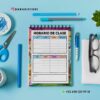 AGENDA DOCENTE PRIMARIAZR 2025-2026 10 Un cuaderno de espiral con el horario de clases está centrado en un escritorio azul con tijeras, sujetapapeles, un bolígrafo, gafas, una planta y un rotulador blanco cerca. El horario está en español y decorado con personajes de dibujos animados.