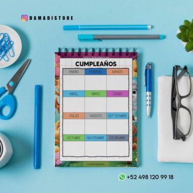 Un organizador de cumpleaños sobre una mesa con material de oficina, incluyendo tijeras, bolígrafos, un lápiz, gafas y sujetapapeles. El organizador tiene los meses en español y espacios para escribir nombres. La información de contacto se muestra en la parte inferior derecha.