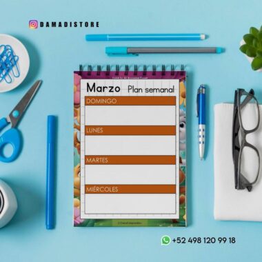 Plano plano de una agenda semanal de marzo sobre una superficie azul, rodeada de tijeras azules, un bolígrafo, un lápiz, gafas, una planta y clips. La agenda tiene secciones en blanco de domingo a miércoles.