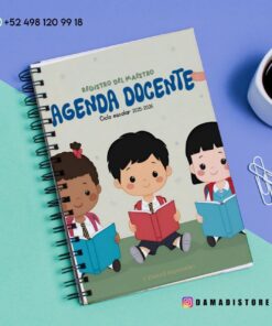Una agenda docente de espiral, titulada "Agenda Docente", con ilustraciones de tres niños leyendo libros, se encuentra sobre un escritorio en tonos pastel con una taza de café, sujetapapeles y un teléfono. Se ven la información de contacto de WhatsApp y las redes sociales.