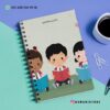 AGENDA DOCENTE PRIMARIA 2025-2026 LEYENDO 19 Un cuaderno de espiral con una portada ilustrada de tres niños leyendo libros, colocado sobre un escritorio colorido con una taza de café, clips y un bolígrafo. También se ven la información de contacto y las redes sociales.