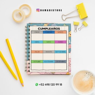 Un cuaderno de cumpleaños con una cuadrícula mensual colorida está sobre un escritorio con lápices amarillos, clips, cinta washi y una taza de café. La información de contacto y la cuenta de Instagram "@damadistore" se ven arriba y abajo del cuaderno.