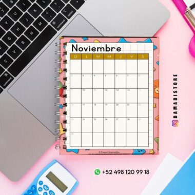 Un calendario de noviembre en espiral con coloridos diseños de animales se encuentra sobre un escritorio rosa junto a una laptop, una calculadora, bolígrafos y un teléfono. La información de contacto y las redes sociales se ven en la esquina inferior derecha.