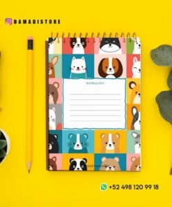 Un colorido cuaderno espiral con adorables caritas de animales en la portada yace sobre una superficie amarilla cerca de un lápiz, un sello de madera, una suculenta y hojas verdes. También se ve la información de contacto de WhatsApp.