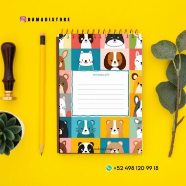 Un colorido cuaderno espiral con adorables caritas de animales en la portada yace sobre una superficie amarilla cerca de un lápiz, un sello de madera, una suculenta y hojas verdes. También se ve la información de contacto de WhatsApp.