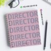 Un cuaderno de espiral rosa con la palabra 