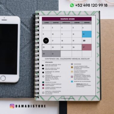 Una agenda encuadernada en espiral abierta hasta marzo de 2026 muestra un calendario mensual con fechas destacadas, una clave para eventos escolares, información de contacto y parte de un smartphone cerca, sobre un escritorio.