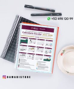 Un cuaderno de espiral con el calendario escolar mexicano 2025-2026 está abierto sobre un escritorio, junto a dos cuadernos cerrados, un bolígrafo y unas gafas. En la imagen aparecen un número de teléfono de WhatsApp y un 