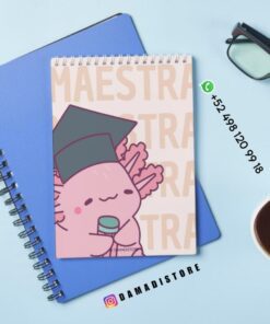 Encima de un cuaderno azul hay un cuaderno de espiral con un simpático dibujo animado de un axolotl que lleva un birrete de graduación y sostiene un diploma. Cerca hay unas gafas, una taza de café y los datos de contacto de DAMADISTORE en la imagen.