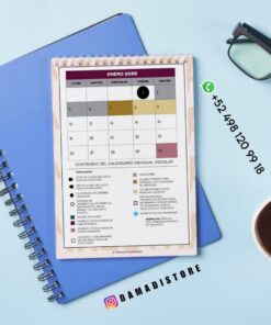 Un calendario encuadernado en espiral para enero de 2026 descansa sobre un cuaderno azul con un bolígrafo. Junto al calendario aparece un número de teléfono de WhatsApp y el usuario de Instagram @DAMADISTORE.