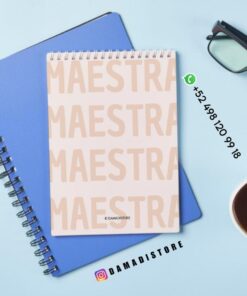 Encima de un cuaderno azul hay un bloc de notas en espiral con la palabra 