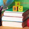Una colorida exhibición de útiles educativos, que incluye una pila de libros, un vaso con lápices de colores, bloques alfabéticos que deletrean "abc" y una manzana roja al lado de un globo terráqueo, que simboliza un ambiente de aprendizaje para el Plan Semestral Proyectos Institucionales II.
